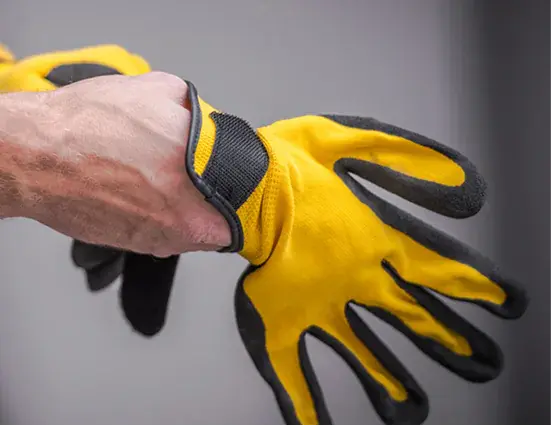 Worker putting on protective work gloves